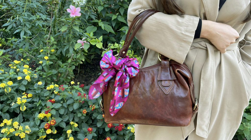 un petit carré de soie coloré noué sur un sac à main